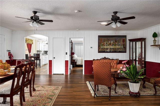 dining room featuring ceiling fan, a textured ceiling, and dark hardwood / wood-style flooring