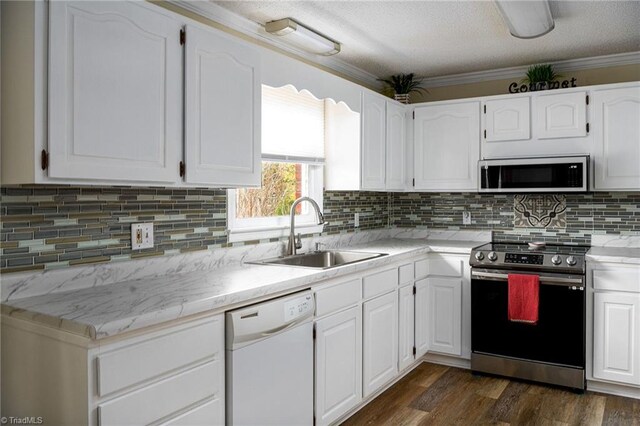 kitchen featuring stainless steel appliances, white cabinetry, sink, and crown molding