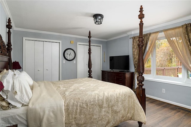 bedroom with ornamental molding, multiple closets, and dark hardwood / wood-style floors