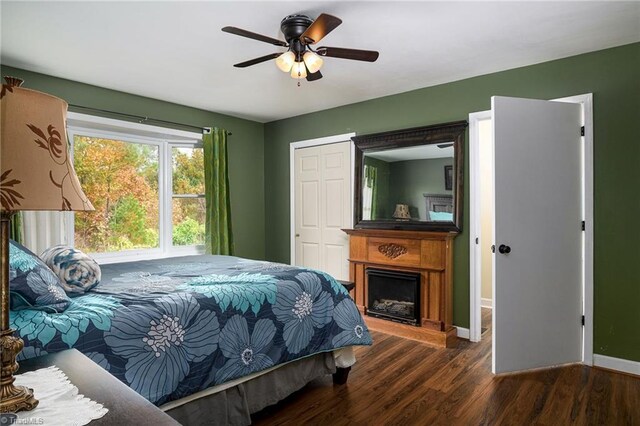 bedroom with ceiling fan, dark hardwood / wood-style floors, and a closet