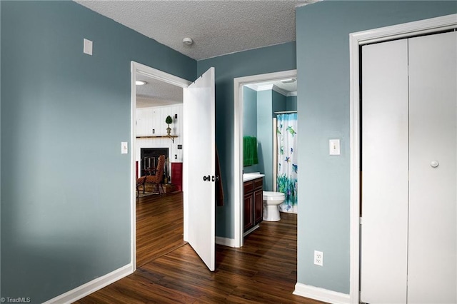 hallway with dark wood-type flooring and a textured ceiling