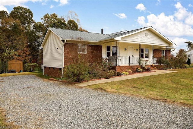 ranch-style home with a front yard, covered porch, a storage shed, an outdoor structure, and crawl space