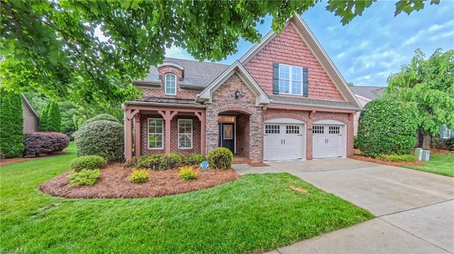 5567 Foxgate Cir, Winston-Salem, NC 27106 - view of front facade with a front lawn, concrete driveway, a garage, stone siding, and brick siding