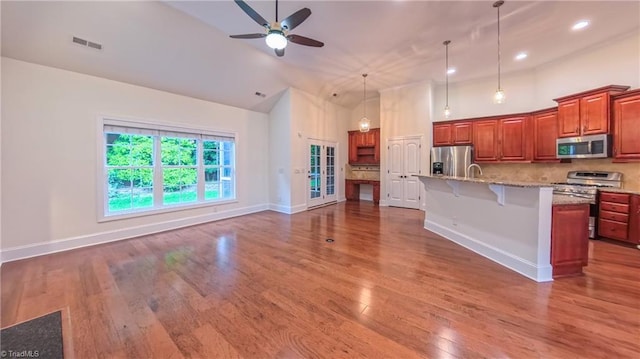 5567 Foxgate Cir, Winston-Salem, NC 27106 - kitchen with stainless steel appliances, high vaulted ceiling, ceiling fan, a kitchen breakfast bar, and decorative light fixtures
