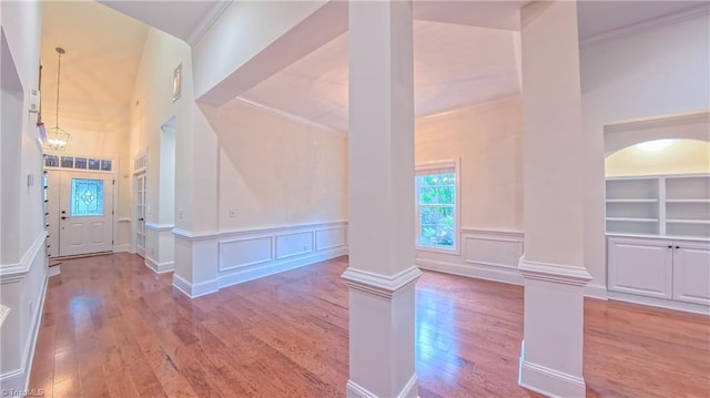 5567 Foxgate Cir, Winston-Salem, NC 27106 - hallway featuring wood-type flooring, ornate columns, a decorative wall, ornamental molding, and arched walkways