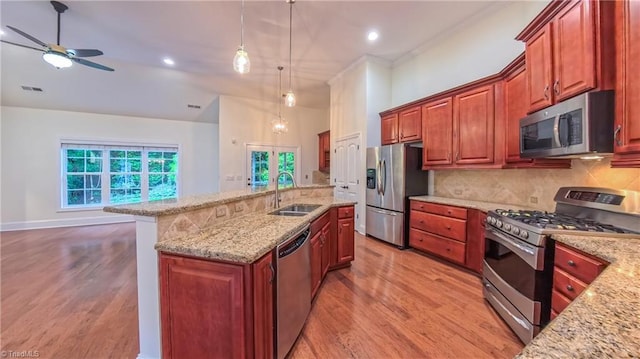 5567 Foxgate Cir, Winston-Salem, NC 27106 - kitchen with stainless steel appliances, light wood-style flooring, an island with sink, tasteful backsplash, and recessed lighting