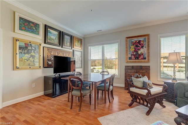 sitting room featuring baseboards, crown molding, and light wood-style floors