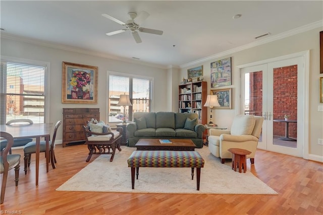 living area featuring visible vents, crown molding, french doors, and light wood-type flooring