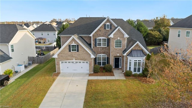 view of front of property featuring a garage, cooling unit, and a front yard