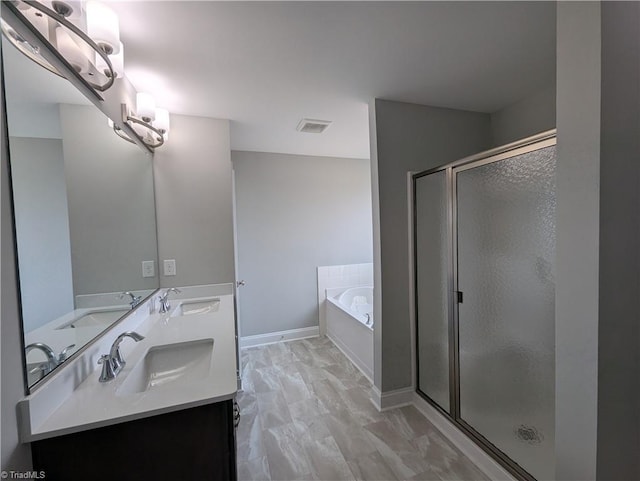 bathroom with vanity and shower with separate bathtub