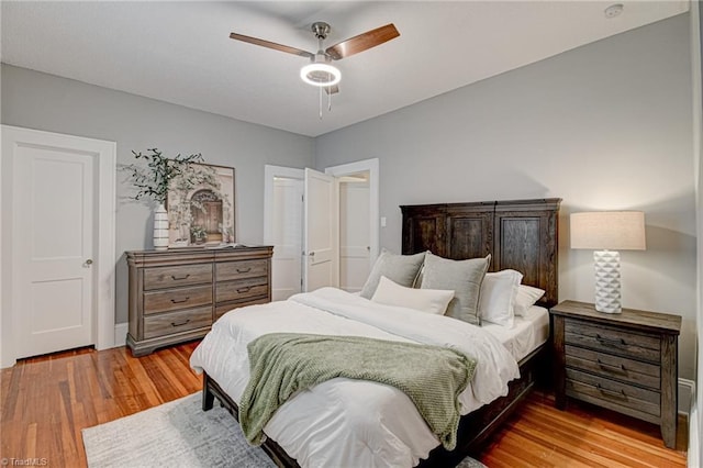 bedroom featuring light wood-type flooring, ceiling fan, and baseboards