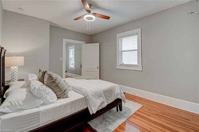 bedroom with baseboards, wood finished floors, and a ceiling fan