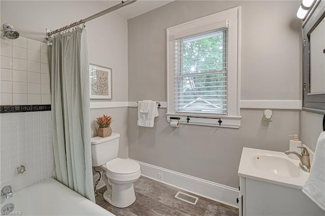 full bath featuring toilet, shower / bath combo, vanity, and baseboards