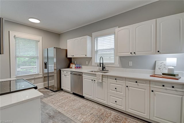 kitchen with stainless steel appliances, a sink, white cabinetry, and light countertops