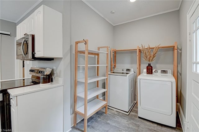 laundry room featuring ornamental molding, washing machine and dryer, healthy amount of natural light, and light wood-style flooring