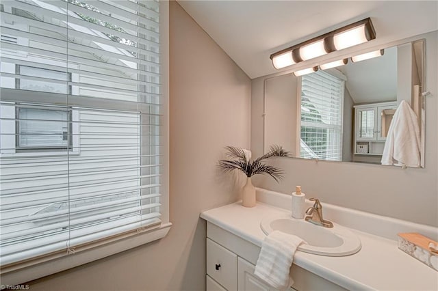 bathroom featuring vaulted ceiling and vanity