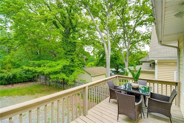 deck with outdoor dining space and a fenced backyard