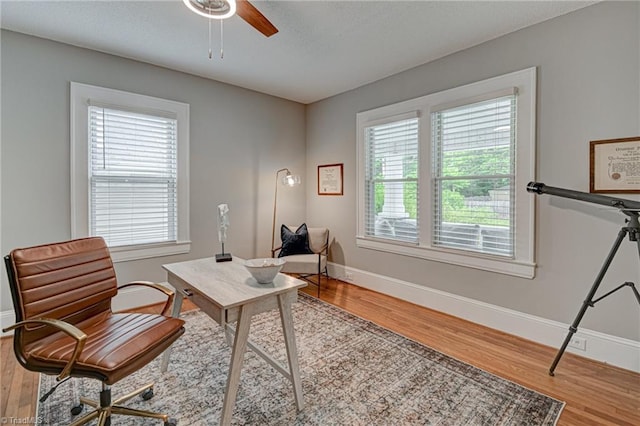 office area featuring wood finished floors, baseboards, and a ceiling fan