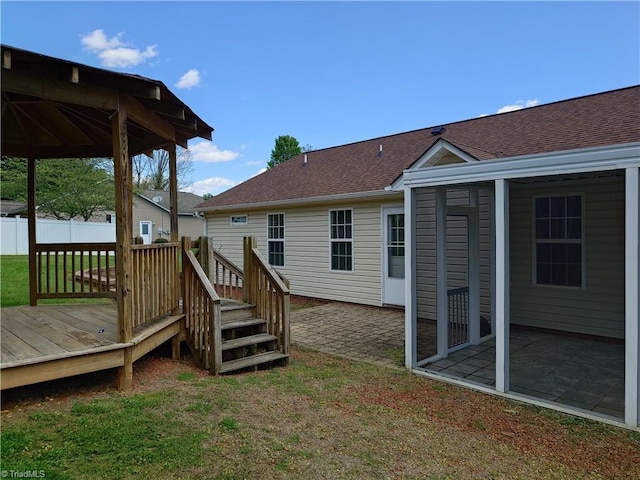 back of house featuring a lawn, a patio, and a wooden deck