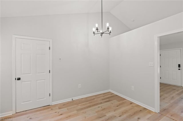 unfurnished dining area featuring baseboards, lofted ceiling, light wood-type flooring, and a chandelier