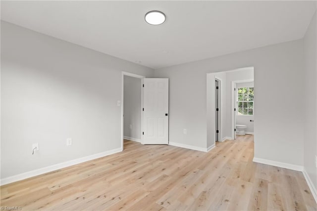 spare room featuring light wood-style floors and baseboards