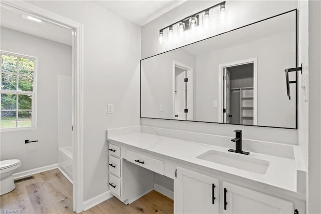 full bath featuring vanity, visible vents, wood finished floors, toilet, and baseboards