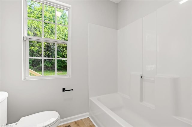 bathroom with baseboards, toilet, and wood finished floors