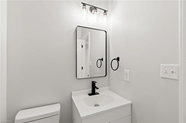 half bath featuring toilet and vanity