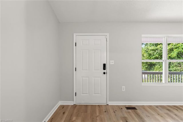 doorway to outside featuring visible vents, light wood-style flooring, and baseboards