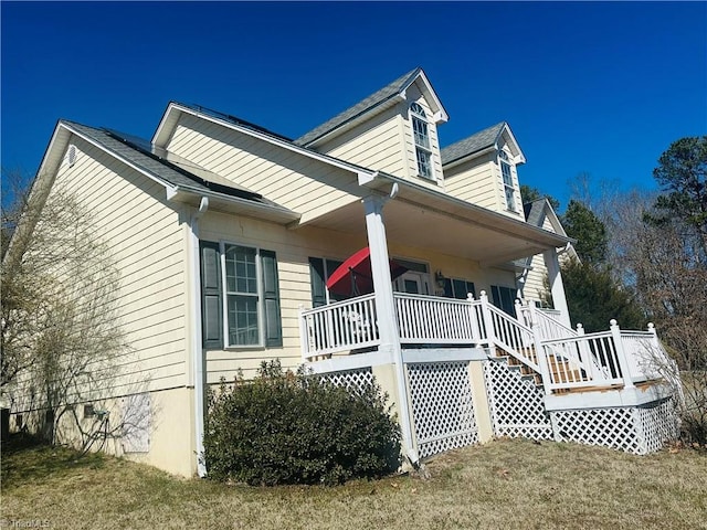 view of side of home with a yard and a porch