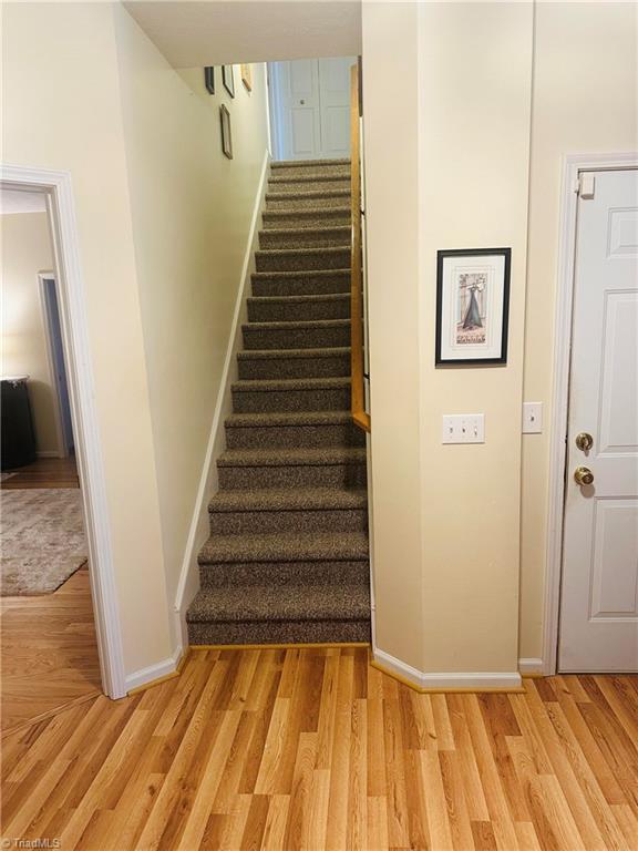 staircase with baseboards and wood finished floors
