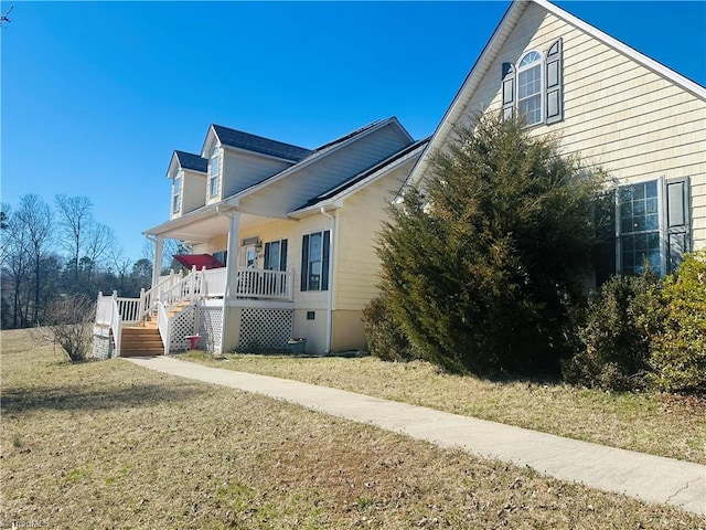 view of side of property with a porch and a lawn