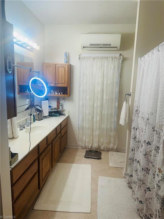 full bathroom featuring vanity and a wall mounted air conditioner