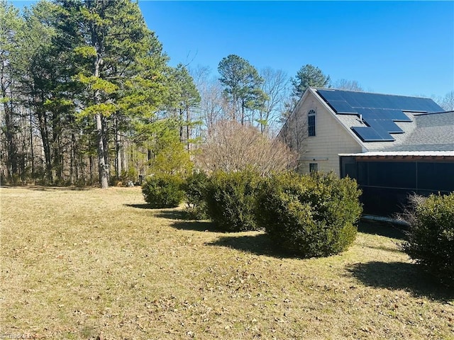 view of property exterior featuring solar panels and a lawn