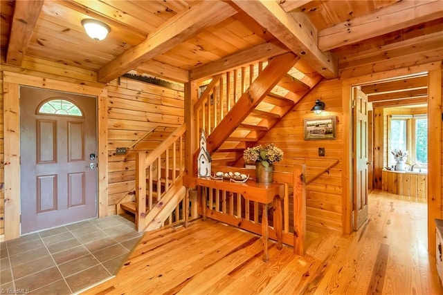 entryway featuring stairs, wood walls, and wood finished floors