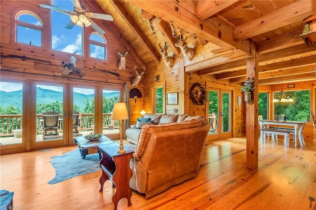 living area with french doors, wood finished floors, wood ceiling, and wooden walls