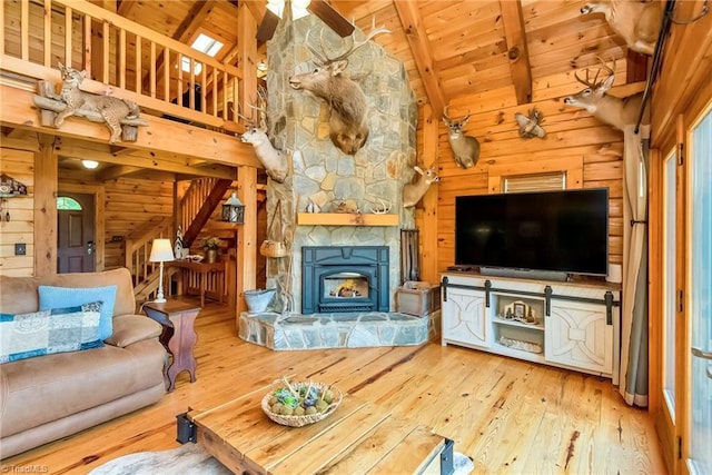 unfurnished living room featuring beam ceiling, wood-type flooring, wood walls, wooden ceiling, and stairs