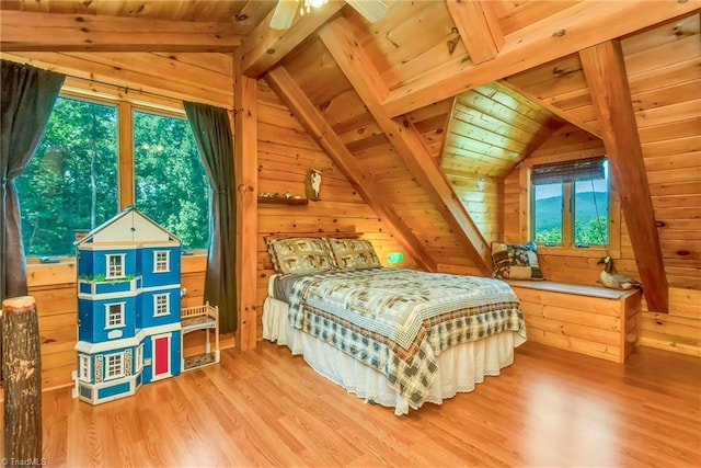 bedroom with vaulted ceiling with beams, wood walls, wood ceiling, and wood finished floors