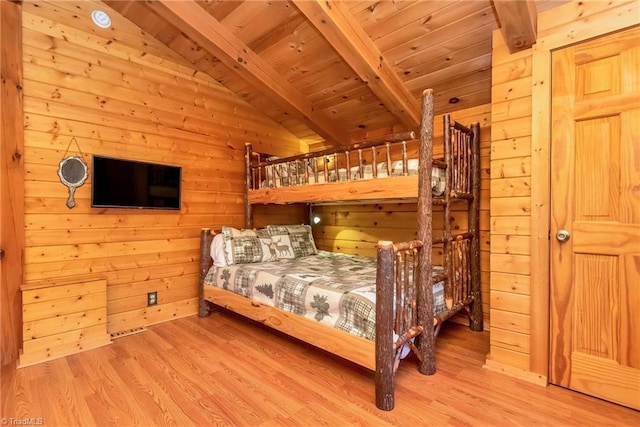 bedroom featuring vaulted ceiling with beams, wood walls, wood finished floors, and wood ceiling