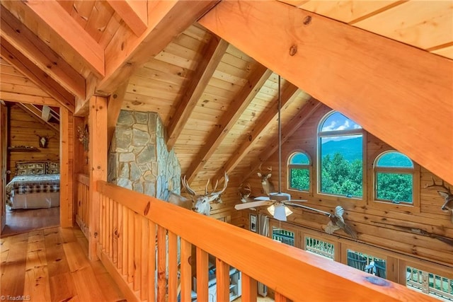 interior space with vaulted ceiling with beams, wood ceiling, and wooden walls