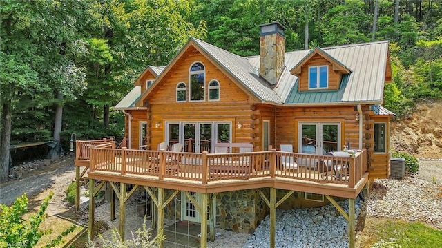 back of house featuring central air condition unit, metal roof, a wooden deck, and log siding