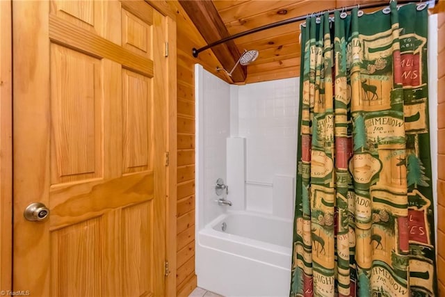 full bath with wood walls and shower / bath combo with shower curtain