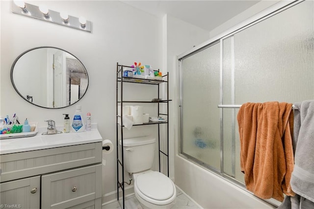 bathroom featuring vanity, toilet, baseboards, and bath / shower combo with glass door