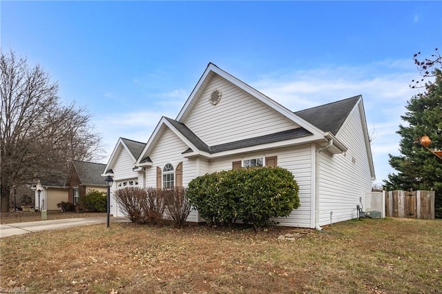 view of side of home featuring a garage and a yard