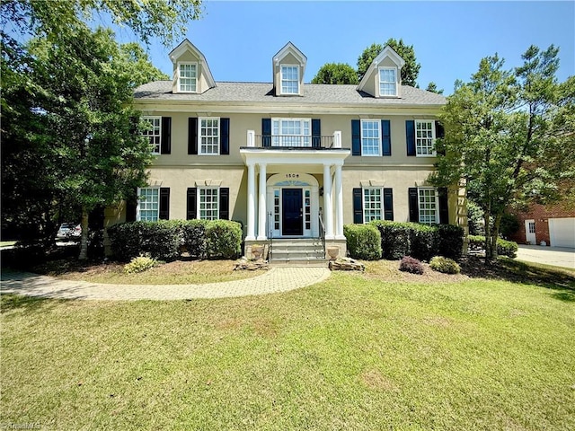 1506 Regents Park Ln, Greensboro, NC 27455 - georgian-style home with a balcony, stucco siding, and a front lawn
