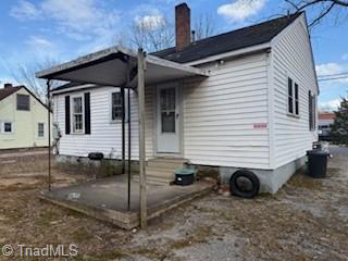 back of property featuring entry steps and a chimney