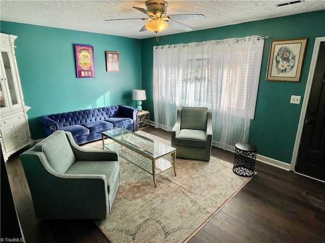 living room featuring ceiling fan, hardwood / wood-style floors, and a textured ceiling