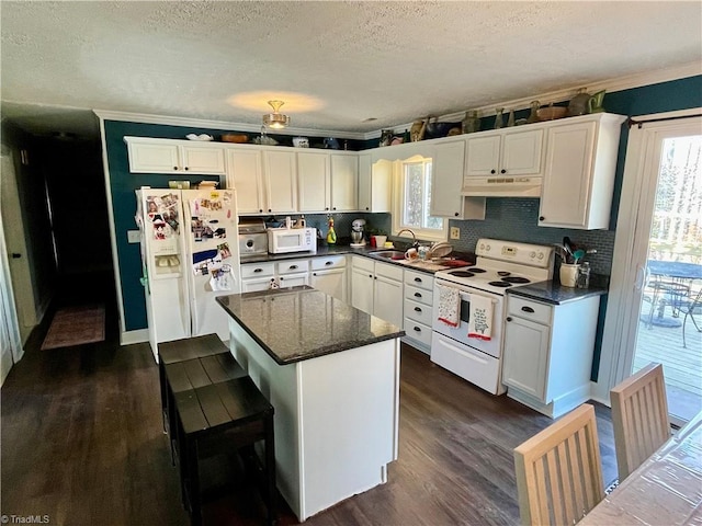 kitchen featuring dark wood-type flooring, sink, a center island, white appliances, and white cabinets