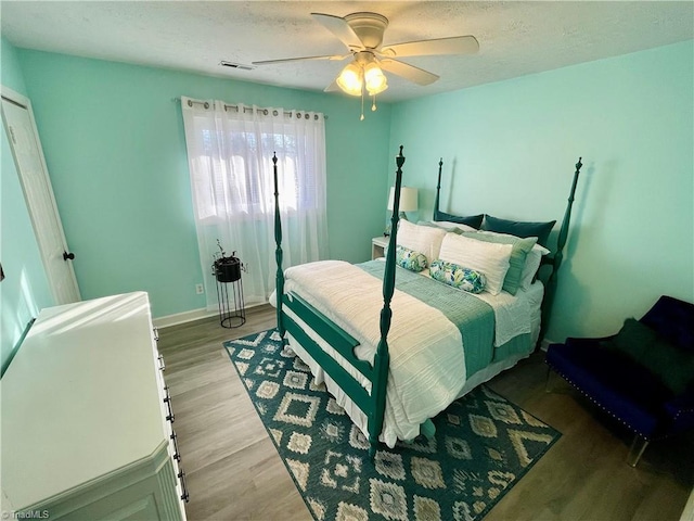 bedroom with ceiling fan and light hardwood / wood-style floors