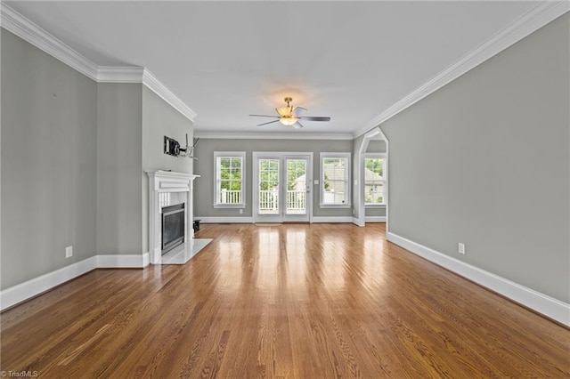 unfurnished living room featuring ornamental molding, a high end fireplace, baseboards, and wood finished floors